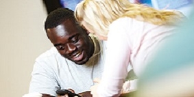 A man and a woman of different races sitting together and smiling.